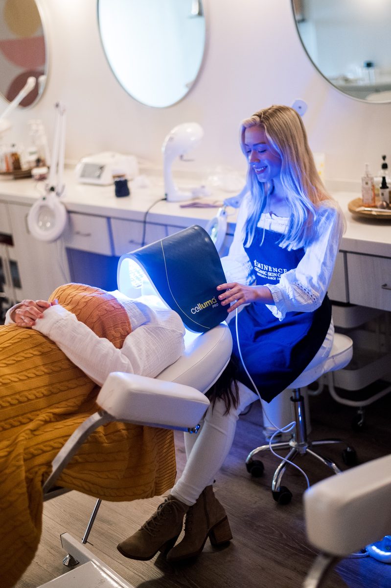 An esthetician guides an LED light treatment