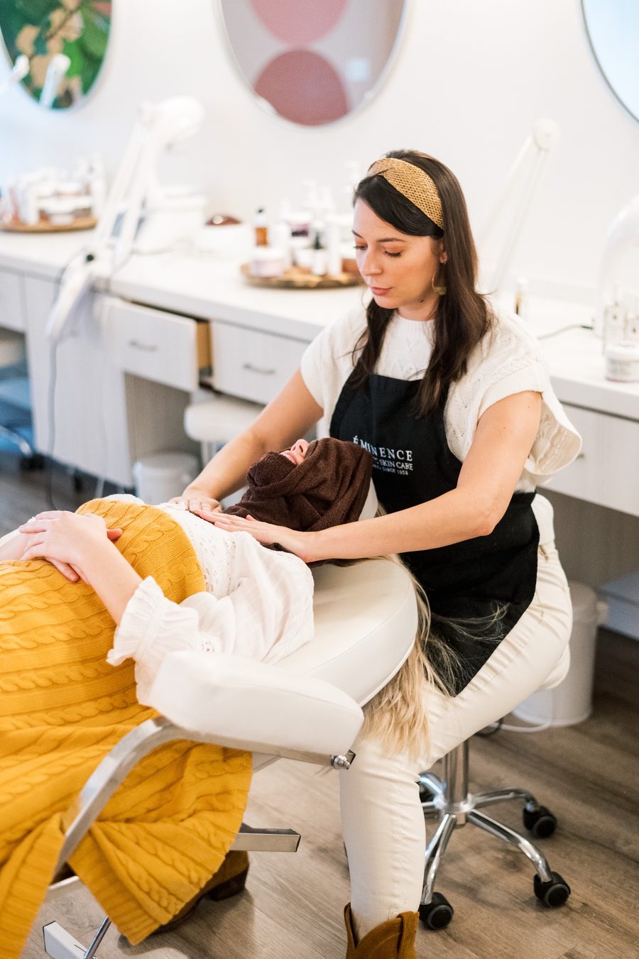Magen Cash giving a guest a relaxing shoulder massage during a facial